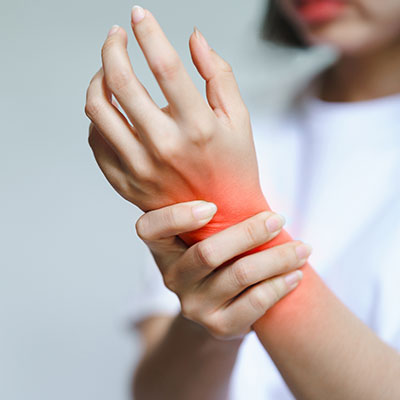 una mujer tiene dolor en la muñeca